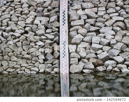 Tool designed to record water reflections and levels along stone riprap walls in city environment Tool designed to record water reflections and levels along stone riprap walls in city environment 142584672
