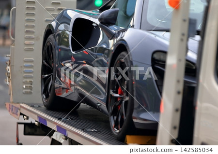 一輛運輸車正在運送一輛跑車 一輛運輸車正在運送一輛跑車 142585034