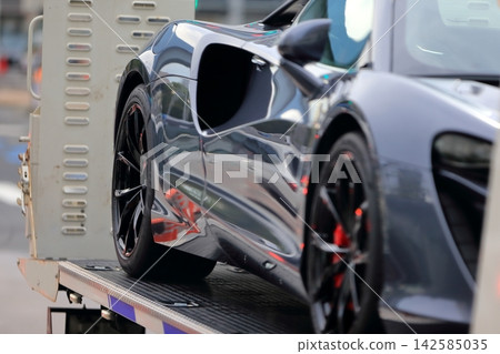 一輛運輸車正在運送一輛跑車 一輛運輸車正在運送一輛跑車 142585035
