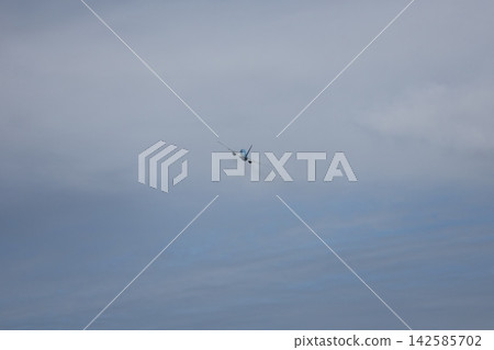 一幅風景畫,展現了一架飛機飛越雲層和藍天的景象。 一幅風景畫,展現了一架飛機飛越雲層和藍天的景象。 142585702