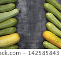 Several colorful zucchini on a wooden surface, showing organic farm produce for food, agriculture, retail, and seasonal content. 142585843
