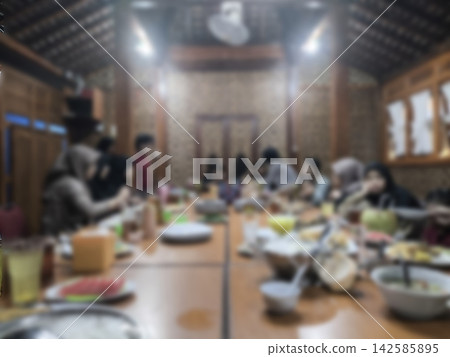 Blurry abstract background warm wooden table filled with shared meals Blurry abstract background warm wooden table filled with shared meals 142585895