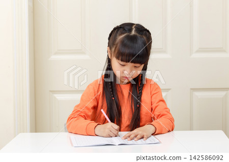 Focused Asian schoolgirl doing homework with hourglass timer, time management and study discipline concept Focused Asian schoolgirl doing homework with hourglass timer, time management and study discipline concept 142586092