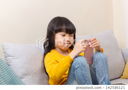 Happy Asian Girls Take Selfies with Smartphones at Home: A Children's Technology Concept Happy Asian Girls Take Selfies with Smartphones at Home: A Children's Technology Concept 142586121