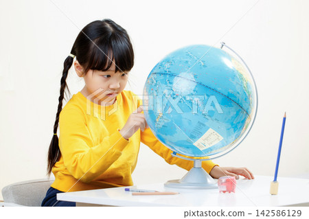 Asian little girl looking at globe, studying geography, focused child learning world map, education concept Asian little girl looking at globe, studying geography, focused child learning world map, education concept 142586129