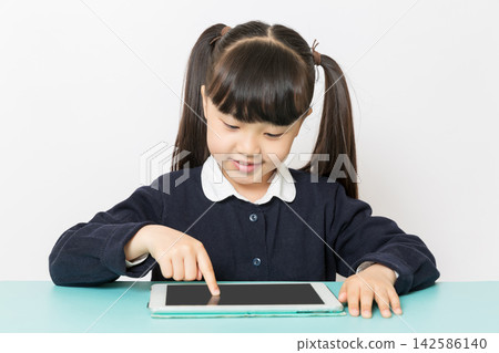 Asian school girl using tablet, online learning and digital education concept, child interacting with touchscreen isolated on white background Asian school girl using tablet, online learning and digital education concept, child interacting with touchscreen isolated on white background 142586140