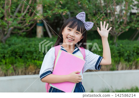 Happy Asian schoolgirl holding books with backpack in park, back to school and education concept 142586214
