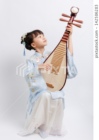 Full length portrait of a young girl playing a traditional Chinese string instrument called Pipa in a studio. Full length portrait of a young girl playing a traditional Chinese string instrument called Pipa in a studio. 142586283