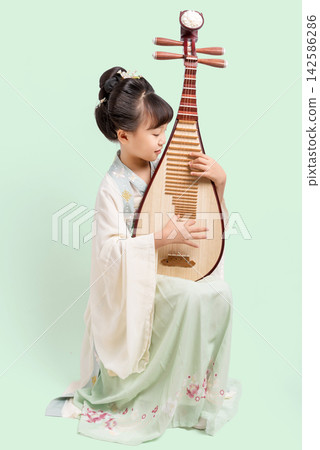 A young Asian girl dressed in traditional Hanfu plays the pipa, showcasing Chinese classical music culture; an elegant portrait of a child musician. A young Asian girl dressed in traditional Hanfu plays the pipa, showcasing Chinese classical music culture; an elegant portrait of a child musician. 142586286