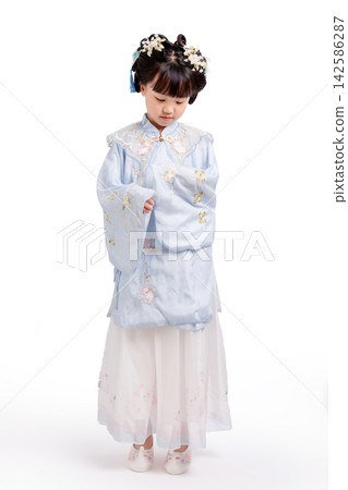 Full length profile of a young girl wearing a traditional light blue Hanfu dress standing against a seamless white background. Full length profile of a young girl wearing a traditional light blue Hanfu dress standing against a seamless white background. 142586287