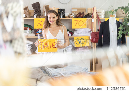 Young woman holding a sign that says sale 142586761