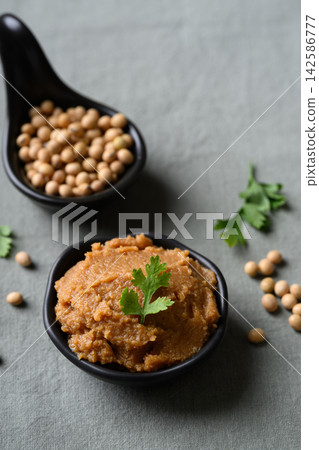 miso paste in a black bowl. Traditional fermented soybean seasoning for Japanese cuisine miso paste in a black bowl. Traditional fermented soybean seasoning for Japanese cuisine 142586777