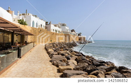 Cozy cafe at narrow promenade of Mediterranean sea in Hammamet, Tunisia. Cozy cafe at narrow promenade of Mediterranean sea in Hammamet, Tunisia. 142586852