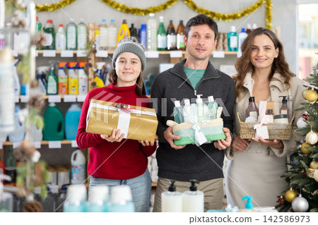 Couple man and woman with daughter chooses cosmetics gift set Couple man and woman with daughter chooses cosmetics gift set 142586973