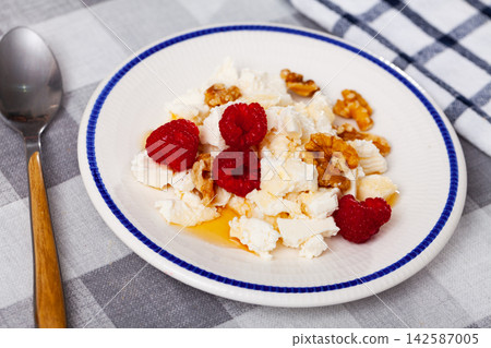 Farm cottage cheese filled with large amount of honey with walnut and raspberry. Farm cottage cheese filled with large amount of honey with walnut and raspberry. 142587005