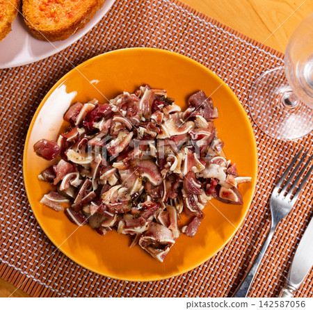 Pieces of pickled and boiled pork ears perfectly complement glass of dark beer. Pieces of pickled and boiled pork ears perfectly complement glass of dark beer. 142587056