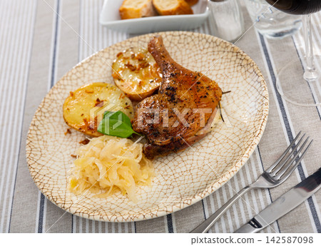 Roast duck leg with potatoes and cabbage on a ceramic plate Roast duck leg with potatoes and cabbage on a ceramic plate 142587098