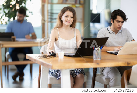 Young male and female colleagues working on laptop in office Young male and female colleagues working on laptop in office 142587236