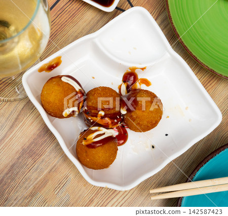 Takoyakis - octopus balls, popular Japanese snack closeup Takoyakis - octopus balls, popular Japanese snack closeup 142587423