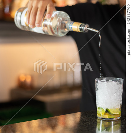 Unrecognizable male bartender prepares cocktail mojito in cafe Unrecognizable male bartender prepares cocktail mojito in cafe 142587760
