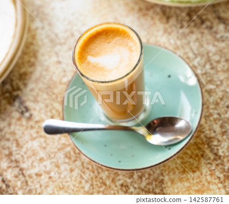 Cortado served with plate with spoon 142587761