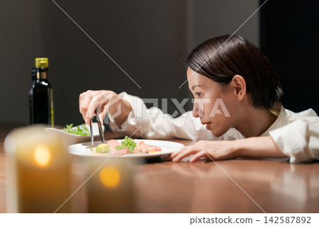 一位表情嚴肅的女廚師正在做飯。 一位表情嚴肅的女廚師正在做飯。 142587892