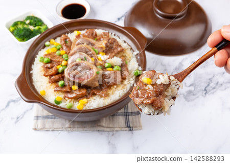 Chinese combo claypot rice with sliced beef and savory cured duck, spoon scooping rice meal Chinese combo claypot rice with sliced beef and savory cured duck, spoon scooping rice meal 142588293