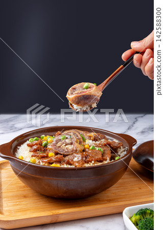 Chinese combo claypot rice with sliced beef and savory cured duck, spoon scooping rice meal Chinese combo claypot rice with sliced beef and savory cured duck, spoon scooping rice meal 142588300