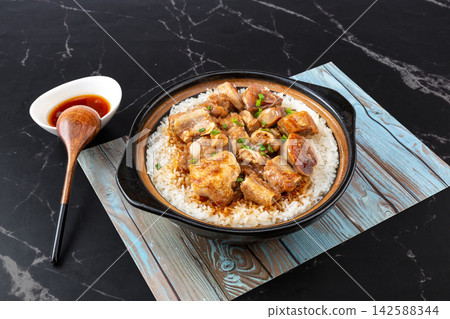 Chinese combo claypot rice with savory pork ribs and cured duck meat on marble background Chinese combo claypot rice with savory pork ribs and cured duck meat on marble background 142588344