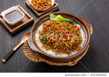Chinese claypot rice with savory minced pork and traditional Hunan preserved wild vegetables, top view Chinese claypot rice with savory minced pork and traditional Hunan preserved wild vegetables, top view 142588360