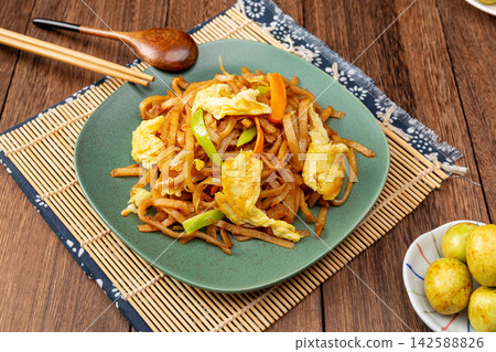 chao Bing, Chinese Stir-Fried Sliced Flatbread with Egg and Vegetables on Wooden Table chao Bing, Chinese Stir-Fried Sliced Flatbread with Egg and Vegetables on Wooden Table 142588826