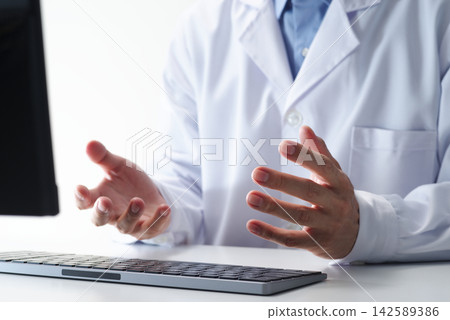 Doctors using computers to provide remote medical care at healthcare facilities. Healthcare professionals utilizing telehealth applications. Doctors using computers to provide remote medical care at healthcare facilities. Healthcare professionals utilizing telehealth applications. 142589386