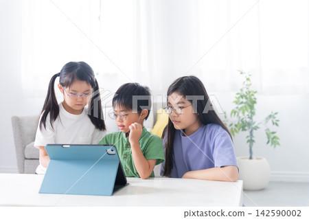 Children studying at home using tablets Children studying at home using tablets 142590002