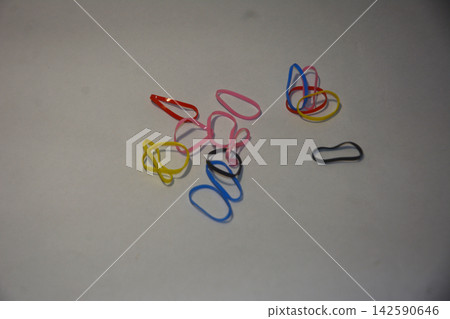 Colorful elastic rubber bands scattered on a plain white surface Colorful elastic rubber bands scattered on a plain white surface 142590646