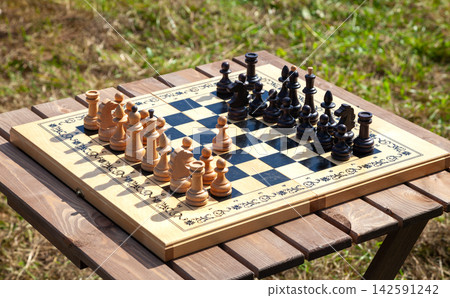 Chessboard with Chess Pieces on Table Chessboard with Chess Pieces on Table 142591242