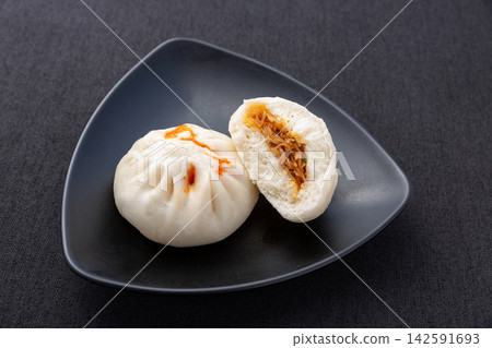 steamed spicy glass noodles buns cut open on black plate, Chinese traditional savory baozi steamed spicy glass noodles buns cut open on black plate, Chinese traditional savory baozi 142591693