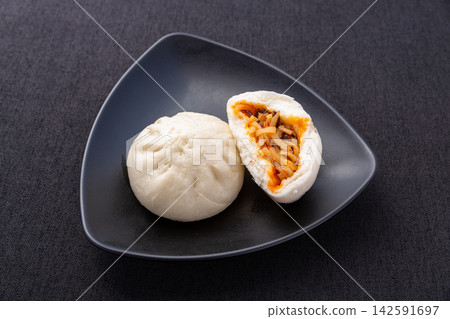 steamed hot and sour shredded potato buns cut open on black plate, Chinese savory baozi steamed hot and sour shredded potato buns cut open on black plate, Chinese savory baozi 142591697