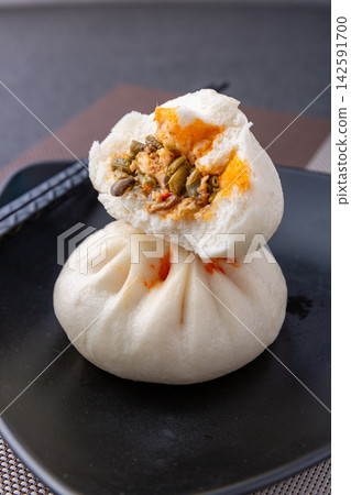 steamed pork and pickled cowpea sour beans buns on black plate, authentic Chinese savory baozi 142591700