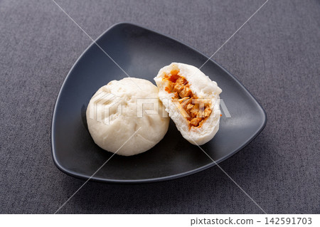 steamed spicy tofu vegetable buns cut open on black plate, Chinese vegetarian baozi dim sum 142591703