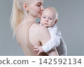 Young Mother Kissing Her Baby Boy on the Head Gently 142592134