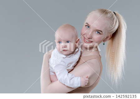 Happy Young Mother Holding Her Baby Boy, Studio Portrait Happy Young Mother Holding Her Baby Boy, Studio Portrait 142592135