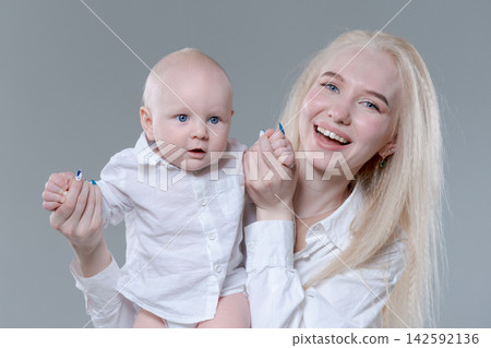 Laughing Young Mother and Her Happy Baby Boy in Studio 142592136