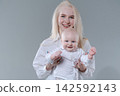 Happy Young Mother Holding Her Baby Boy, Studio Portrait 142592143