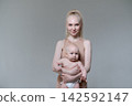 Happy Young Mother Holding Her Bare Baby Boy in Studio 142592147