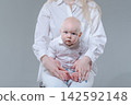 Tiny Baby Feet on Mother Lap, Panoramic Studio Crop 142592148
