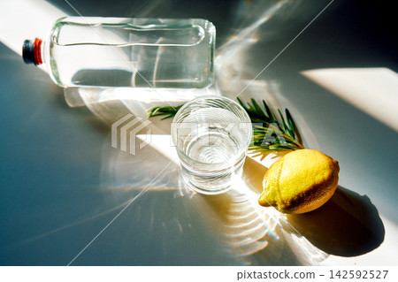 Refreshing water with lemon and rosemary in sunlight Refreshing water with lemon and rosemary in sunlight 142592527