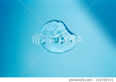 Clear serum liquid drop texture on blue background Clear serum liquid drop texture on blue background 142592531