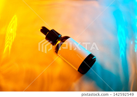 Serum dropper bottle with label on dynamic colored surface Serum dropper bottle with label on dynamic colored surface 142592549