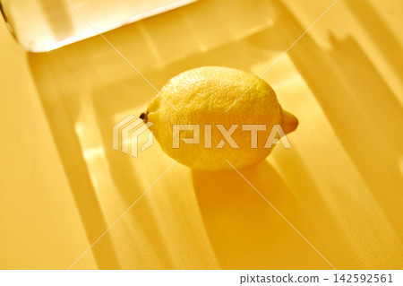 Lemon with glass shadows on yellow background 142592561