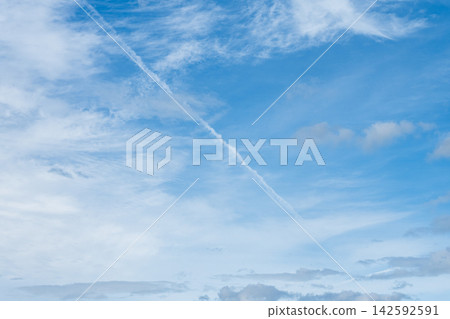 飛機尾跡橫亙在夏末的藍天和雲層之上。 飛機尾跡橫亙在夏末的藍天和雲層之上。 142592591